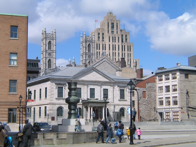 Place d'Youville et le Centre d'hisoire de Montréal. En fond, les flèches de la basilique Notre-Dame et le plus vieux gratte-ciel (1888) de Montréal