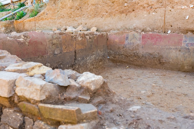 Conservés sur 80 cm de haut, les murs sont décorés de fresques imitant le marbre. © Flore Giraud, Inrap